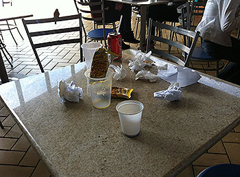 Lixo deixado pelos alunos nas mesas da praça de alimentação